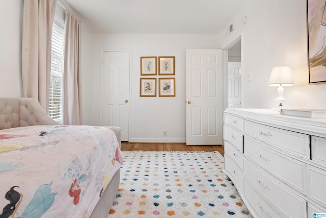 bedroom with visible vents and light wood-style flooring