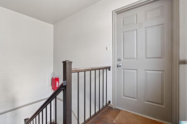 corridor featuring dark wood-style floors and an upstairs landing