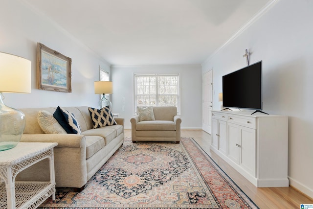 living area with light wood-type flooring, baseboards, and ornamental molding