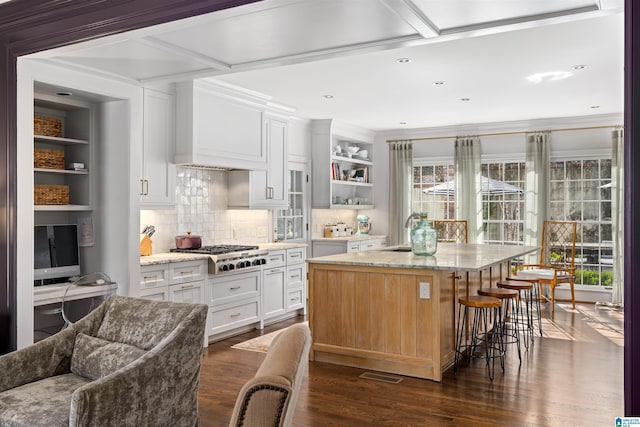 kitchen with stainless steel gas cooktop, dark wood-style flooring, white cabinetry, custom exhaust hood, and open shelves