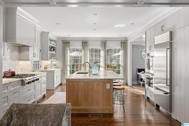 kitchen featuring appliances with stainless steel finishes, dark wood finished floors, a sink, and tasteful backsplash