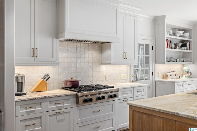 kitchen featuring white cabinetry, custom exhaust hood, decorative backsplash, light stone countertops, and stainless steel gas stovetop