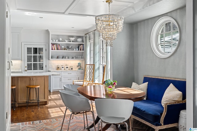 dining area with brick floor, an inviting chandelier, and crown molding