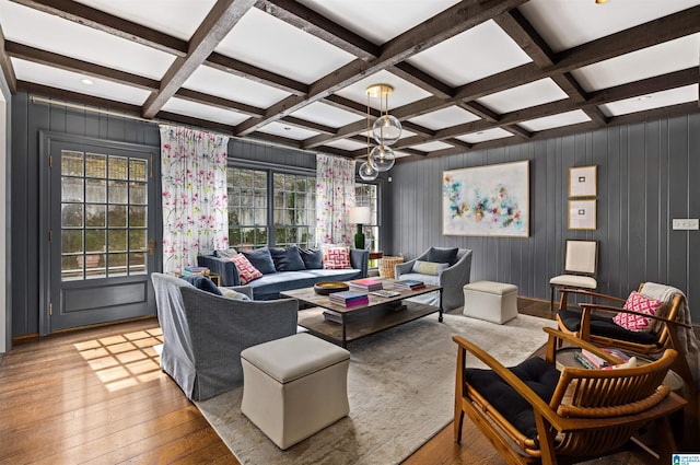 living area featuring beam ceiling, coffered ceiling, hardwood / wood-style flooring, and an inviting chandelier