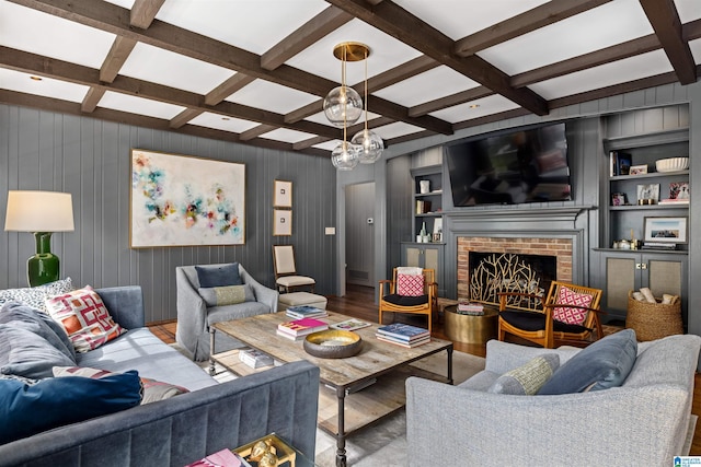 living area featuring built in features, beam ceiling, a brick fireplace, wood finished floors, and coffered ceiling