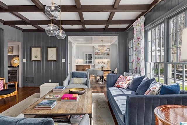 living area with beverage cooler, coffered ceiling, wood finished floors, and beam ceiling