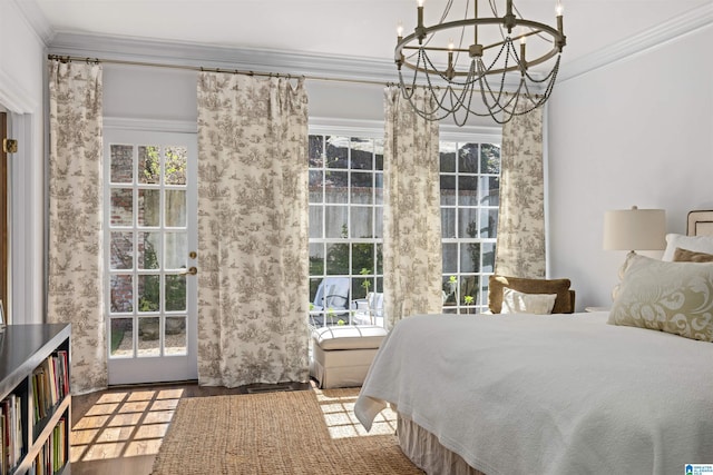 bedroom featuring ornamental molding, a chandelier, multiple windows, and wood finished floors