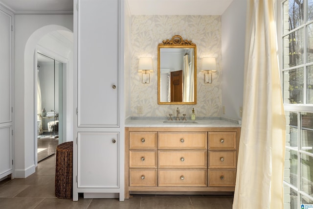 bathroom featuring tile patterned flooring, vanity, and wallpapered walls