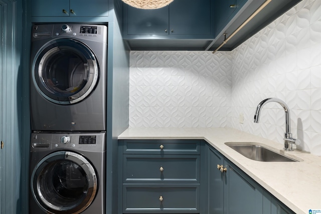 laundry area featuring cabinet space, a sink, and stacked washer and clothes dryer