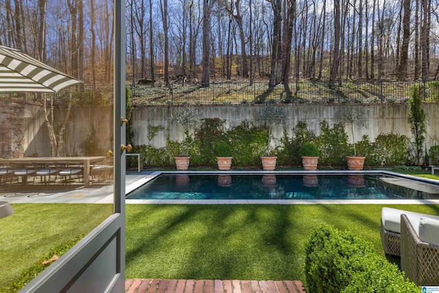 view of swimming pool featuring a fenced in pool, a fenced backyard, and a yard