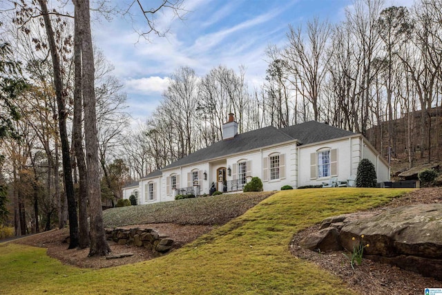 view of front of house featuring a front lawn and a chimney