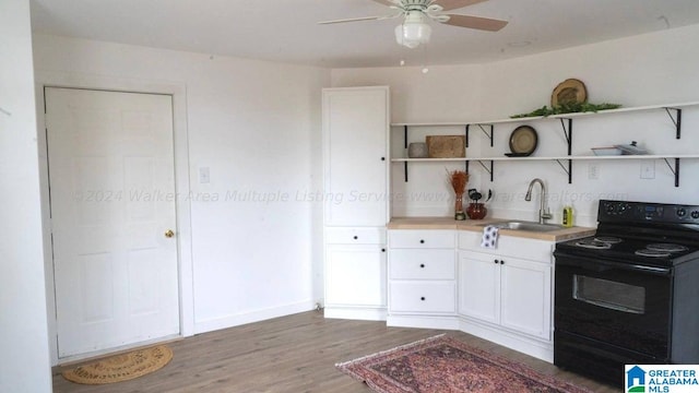 kitchen featuring black / electric stove, a sink, white cabinets, open shelves, and light wood finished floors