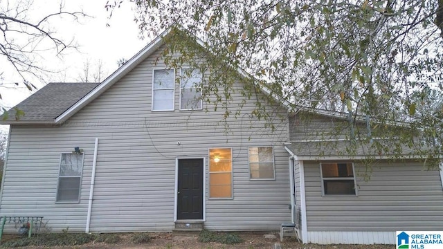 rear view of house featuring a shingled roof