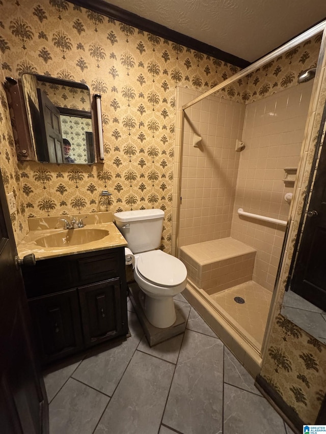 bathroom with a textured ceiling, a shower stall, vanity, and wallpapered walls