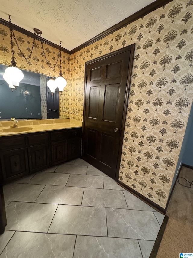 bathroom with wallpapered walls, ornamental molding, a textured ceiling, and vanity