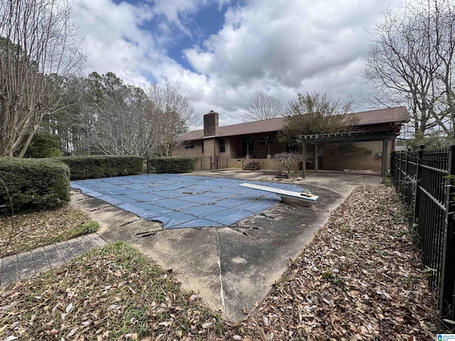 view of pool featuring a fenced in pool, fence, a patio area, a diving board, and a pergola