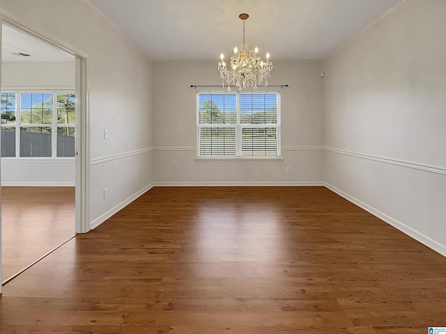 unfurnished dining area with a chandelier, ornamental molding, wood finished floors, and baseboards