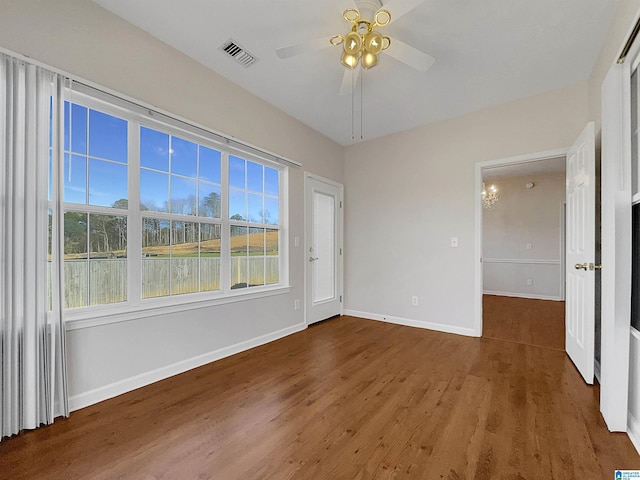 spare room featuring a ceiling fan, baseboards, visible vents, and wood finished floors