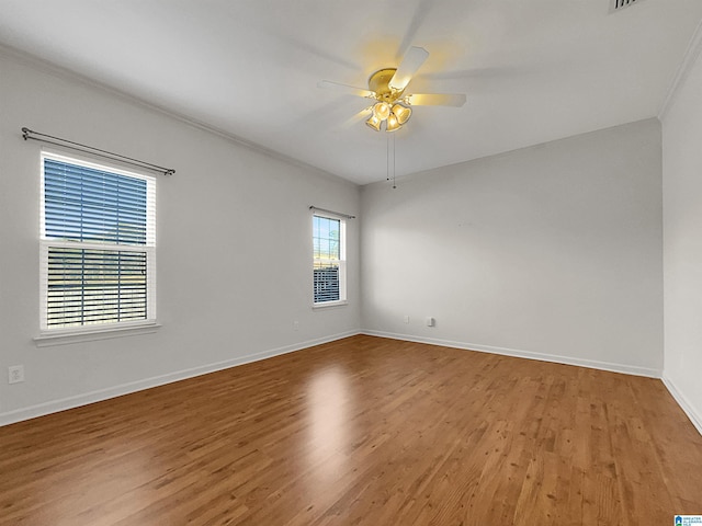 unfurnished room with light wood-type flooring, a ceiling fan, and baseboards