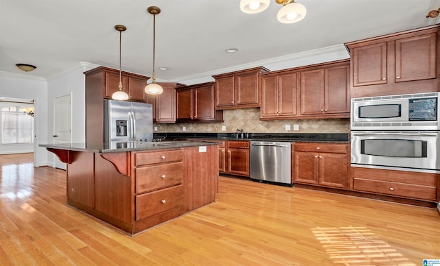 kitchen featuring appliances with stainless steel finishes, decorative backsplash, light wood-style flooring, and crown molding