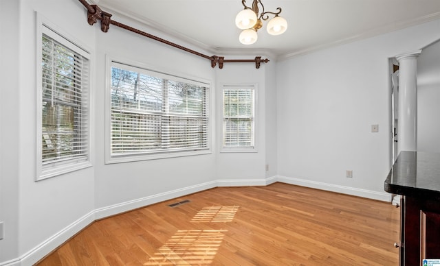 unfurnished dining area featuring a chandelier, light wood-style flooring, visible vents, baseboards, and ornamental molding