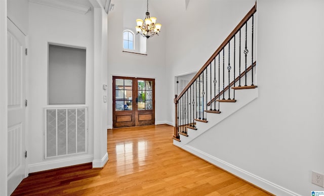 foyer entrance featuring wood finished floors, visible vents, baseboards, stairs, and french doors