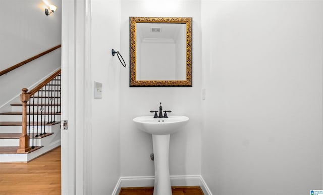 bathroom with a sink, baseboards, and wood finished floors