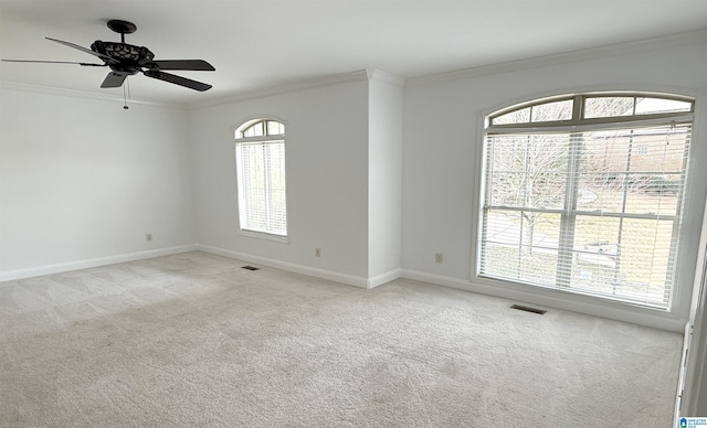 unfurnished room with light carpet, ornamental molding, visible vents, and baseboards