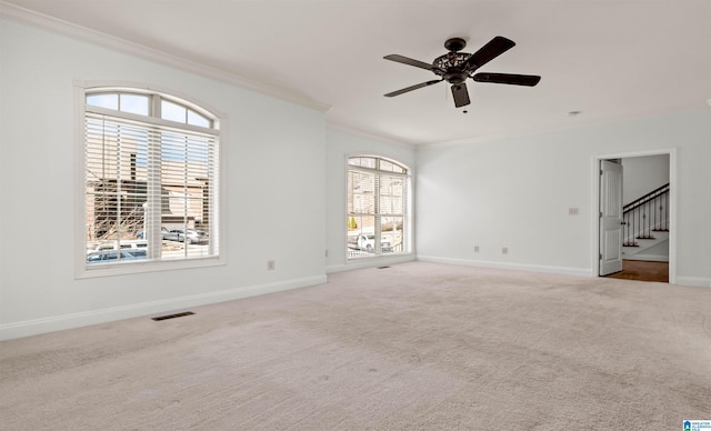 spare room featuring baseboards, visible vents, carpet flooring, and ornamental molding