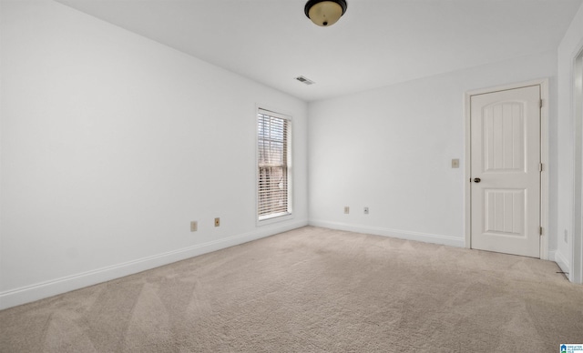 unfurnished room featuring light carpet, visible vents, and baseboards