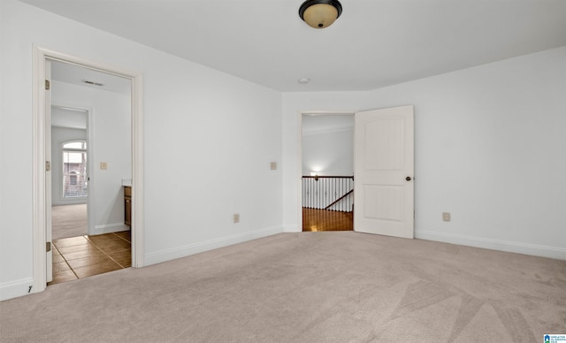 unfurnished bedroom featuring carpet floors, baseboards, and visible vents