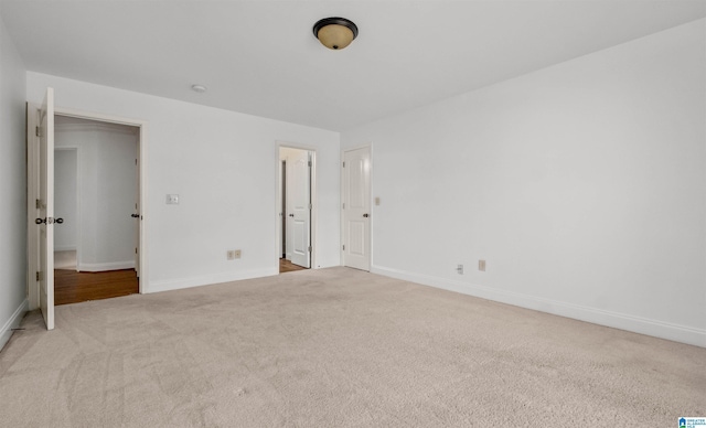 unfurnished bedroom featuring baseboards and light colored carpet