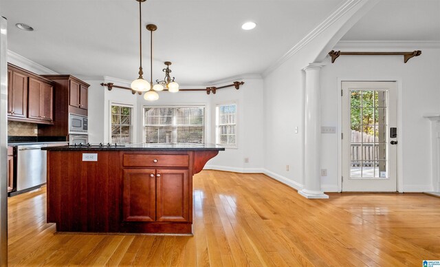 kitchen featuring dark countertops, ornate columns, appliances with stainless steel finishes, and light wood finished floors