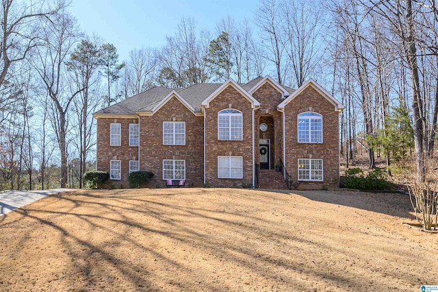 view of front of home featuring brick siding and a front yard