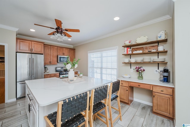 kitchen featuring appliances with stainless steel finishes, built in study area, wood tiled floor, open shelves, and crown molding