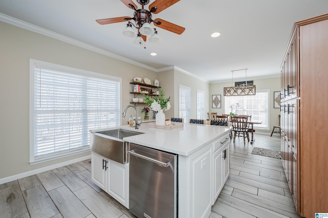 kitchen with an island with sink, wood tiled floor, crown molding, stainless steel dishwasher, and a sink