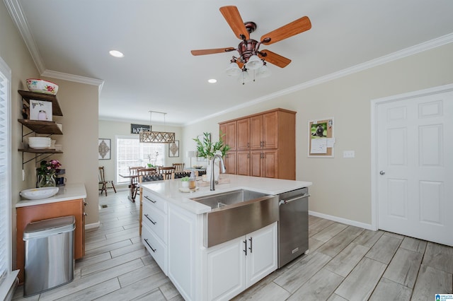 kitchen featuring light countertops, stainless steel dishwasher, wood finish floors, and a sink