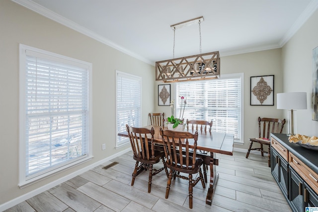 dining room featuring visible vents, baseboards, crown molding, and wood finish floors