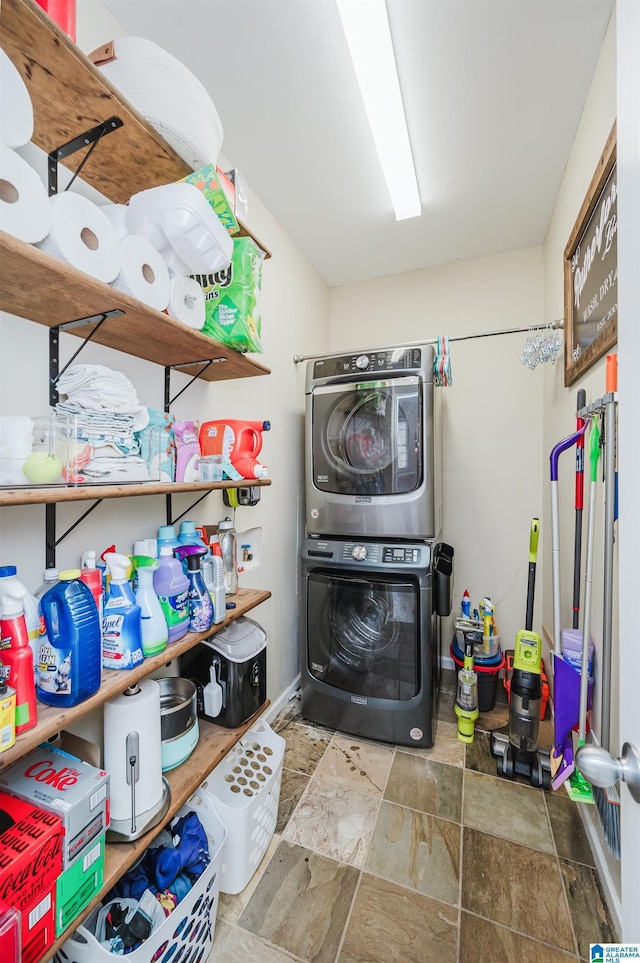 laundry room with laundry area, stone finish floor, and stacked washer / dryer