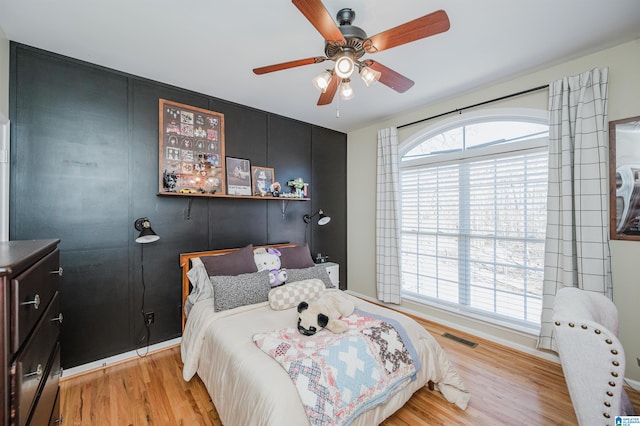 bedroom with visible vents, light wood-style flooring, and multiple windows