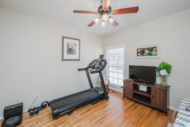 workout room with ceiling fan, light wood-style flooring, and baseboards