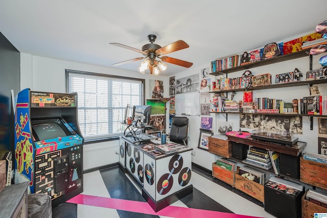 playroom with ceiling fan and baseboards