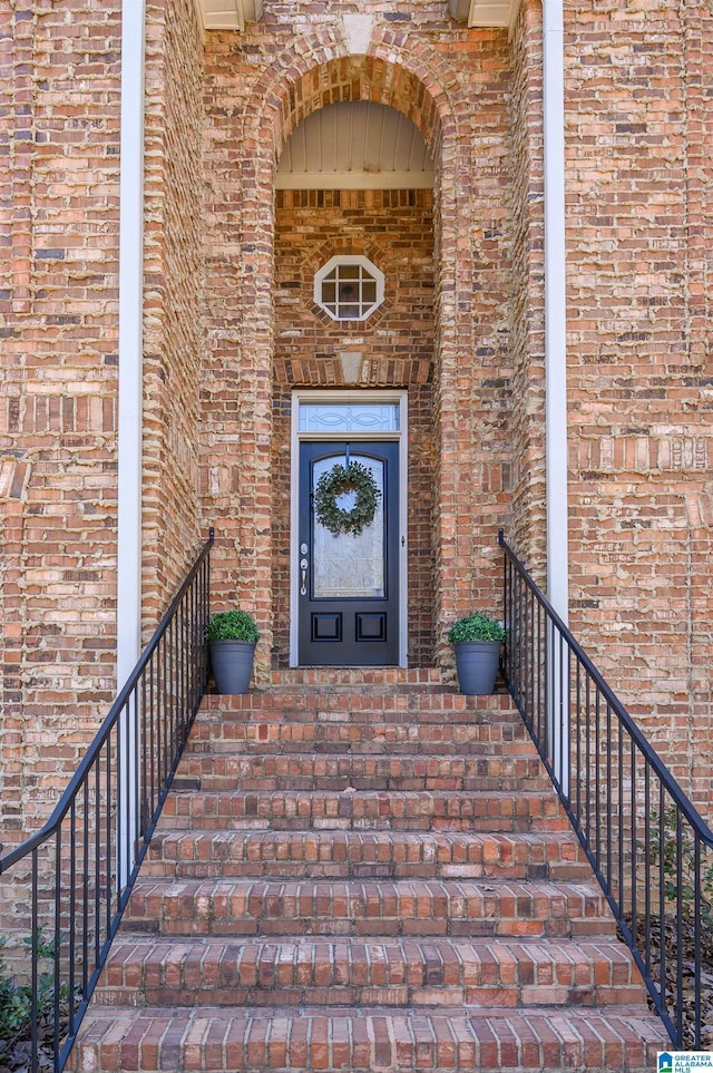 view of exterior entry with brick siding