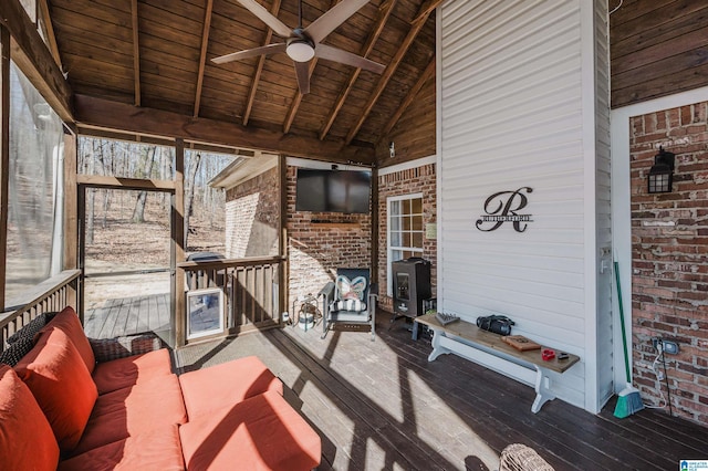 unfurnished sunroom with lofted ceiling with beams, wooden ceiling, and a ceiling fan