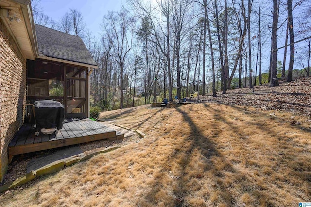 view of yard with a sunroom and a wooden deck