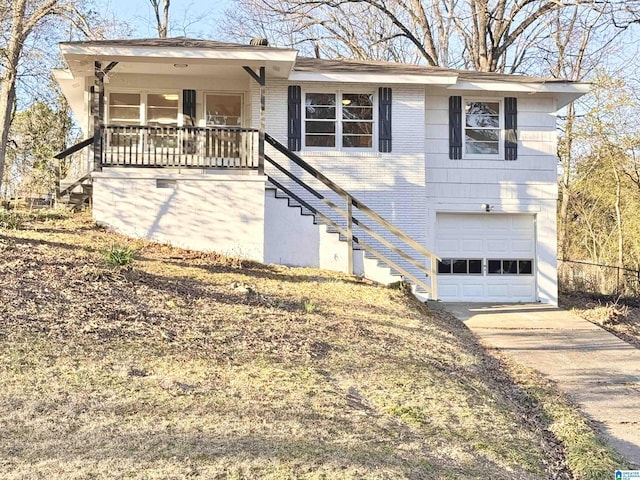 single story home with concrete driveway, an attached garage, stairs, a porch, and brick siding