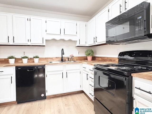 kitchen featuring light wood-style floors, white cabinetry, a sink, and black appliances