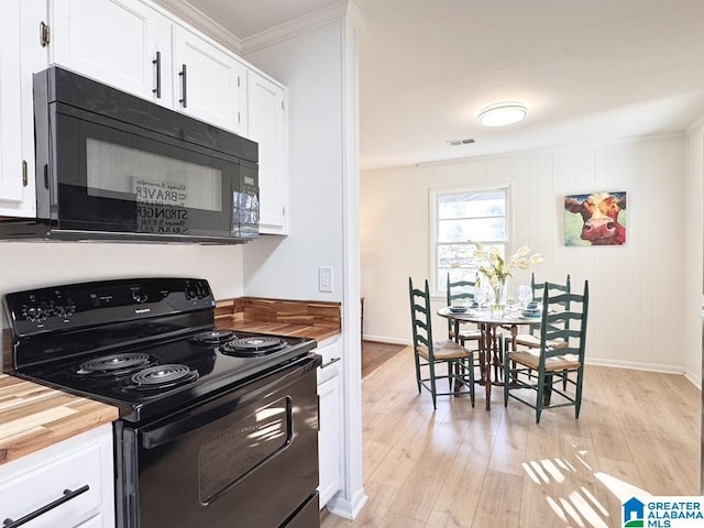 kitchen featuring black appliances, butcher block counters, white cabinetry, and light wood-style floors