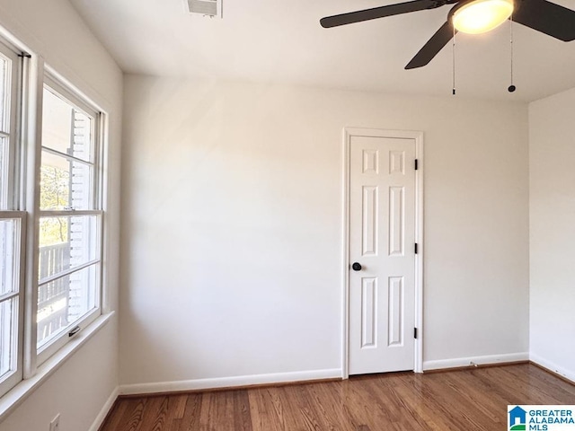 unfurnished room with visible vents, baseboards, and wood finished floors