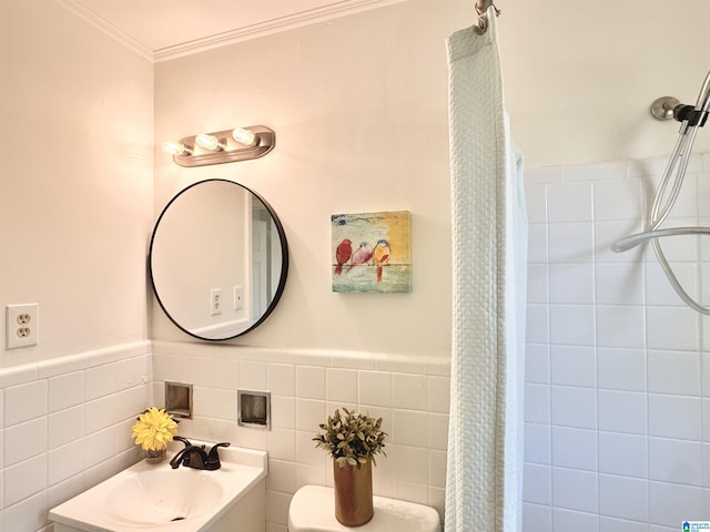 bathroom with crown molding, a sink, a tile shower, and toilet